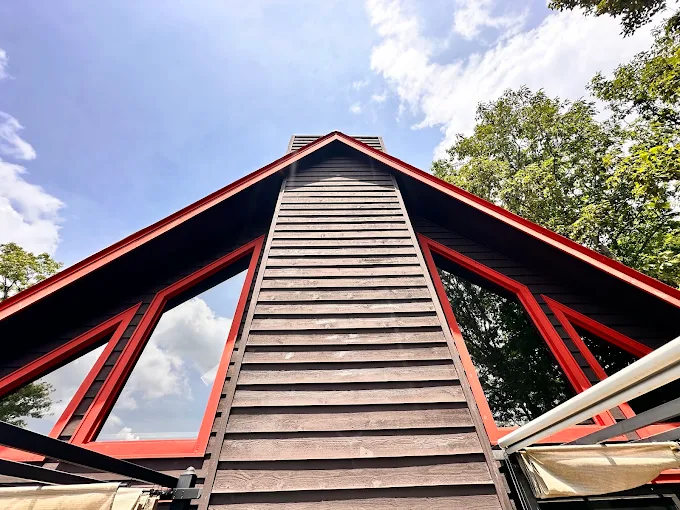 A-frame mountain cabin with 3M-tinted windows reflecting the North Georgia sky
